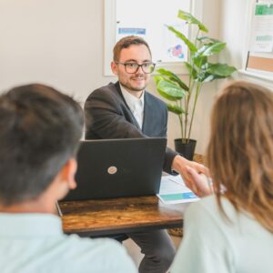 A mortgage broker meeting clients in an office, discussing agreements and loans.