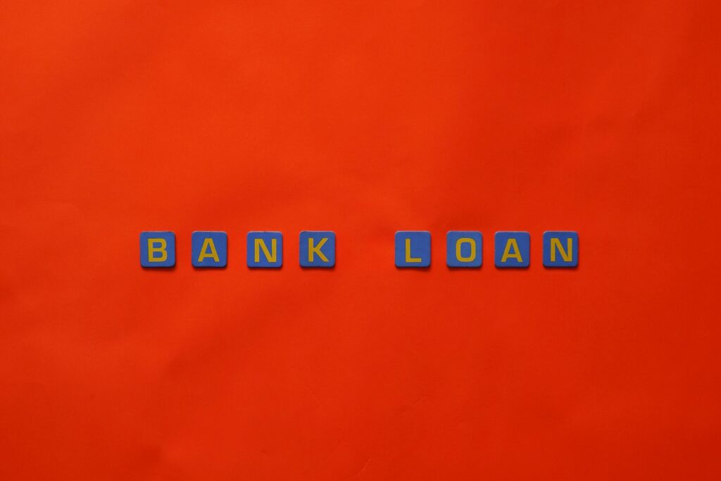 Letters forming 'Bank Loan' on a vibrant red surface, ideal for finance themes.